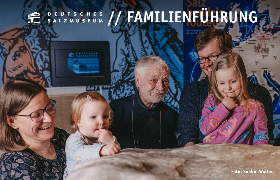 Eine Familie steht im Salzmuseum Lüneburg an einem großen Salzblock.